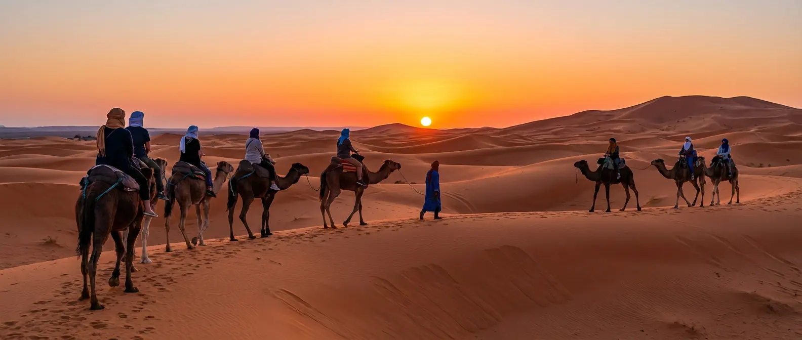 American tourists riding camels at sunset in Merzouga Sahara during a Morocco desert tour, showing the experience included in 3-day and 4-day desert tours